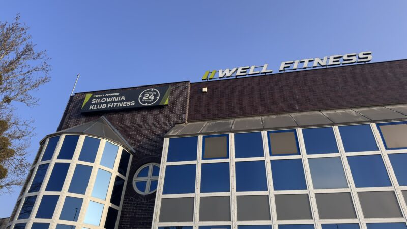 Зовнішній вигляд будівлі клубу «Well Fitness Wrocław Grabiszyn» з цілодобовим освітленням.