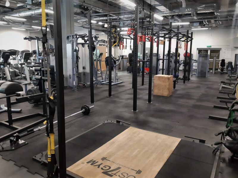 Кімната з великою кількістю турніків, штанги, стрічок TRX та боксу.