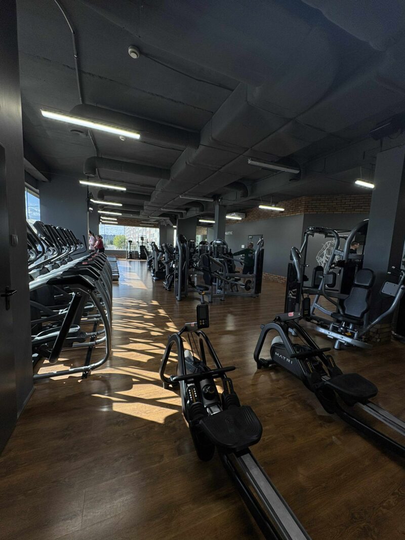 Орбітреки та тренажерні сходи в кардіозоні фітнес-клубу.