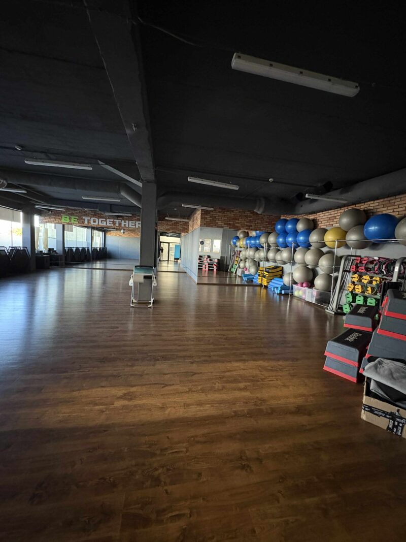 Фітнес-зал з дзеркалами та учасниками груп.