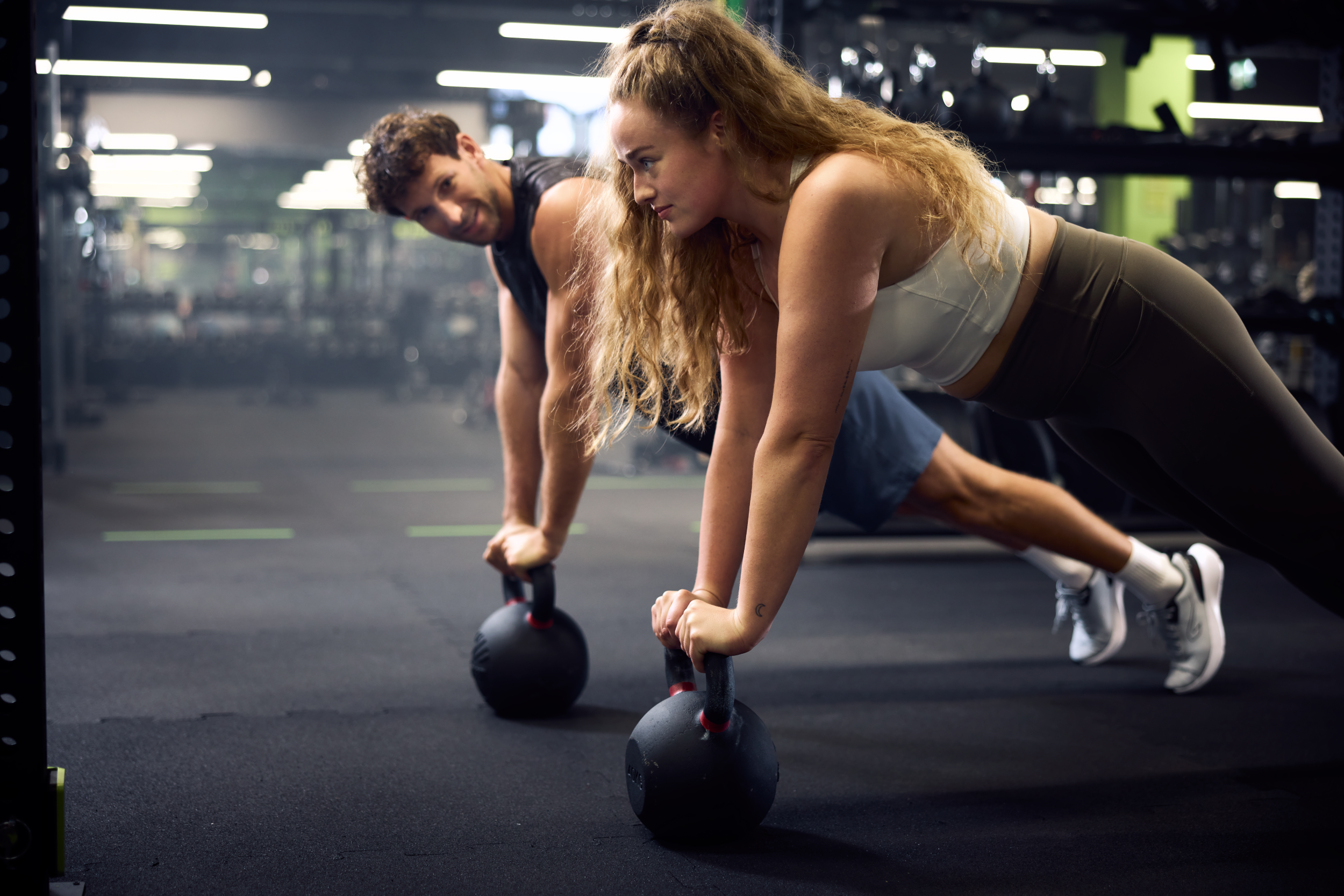 Para trenująca na kettlebellach w klubie fitness – circuit training