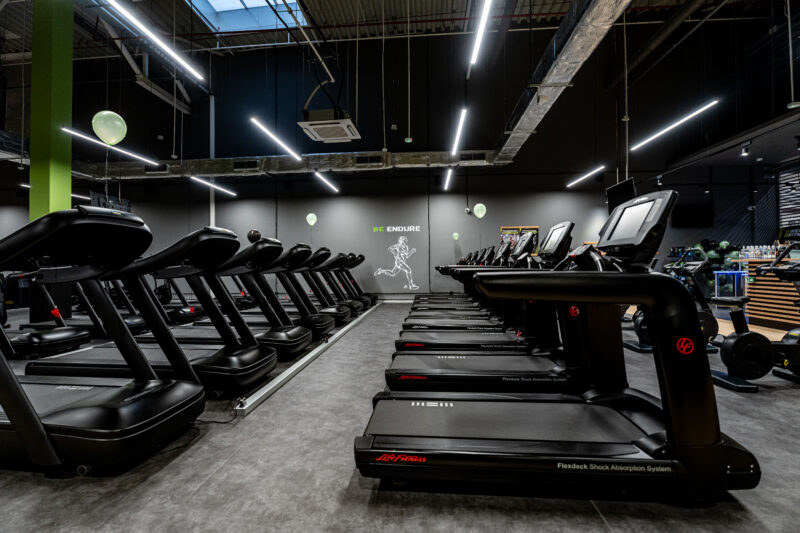 Rząd nowoczesnych bieżni Life Fitness w strefie cardio klubu Well Fitness