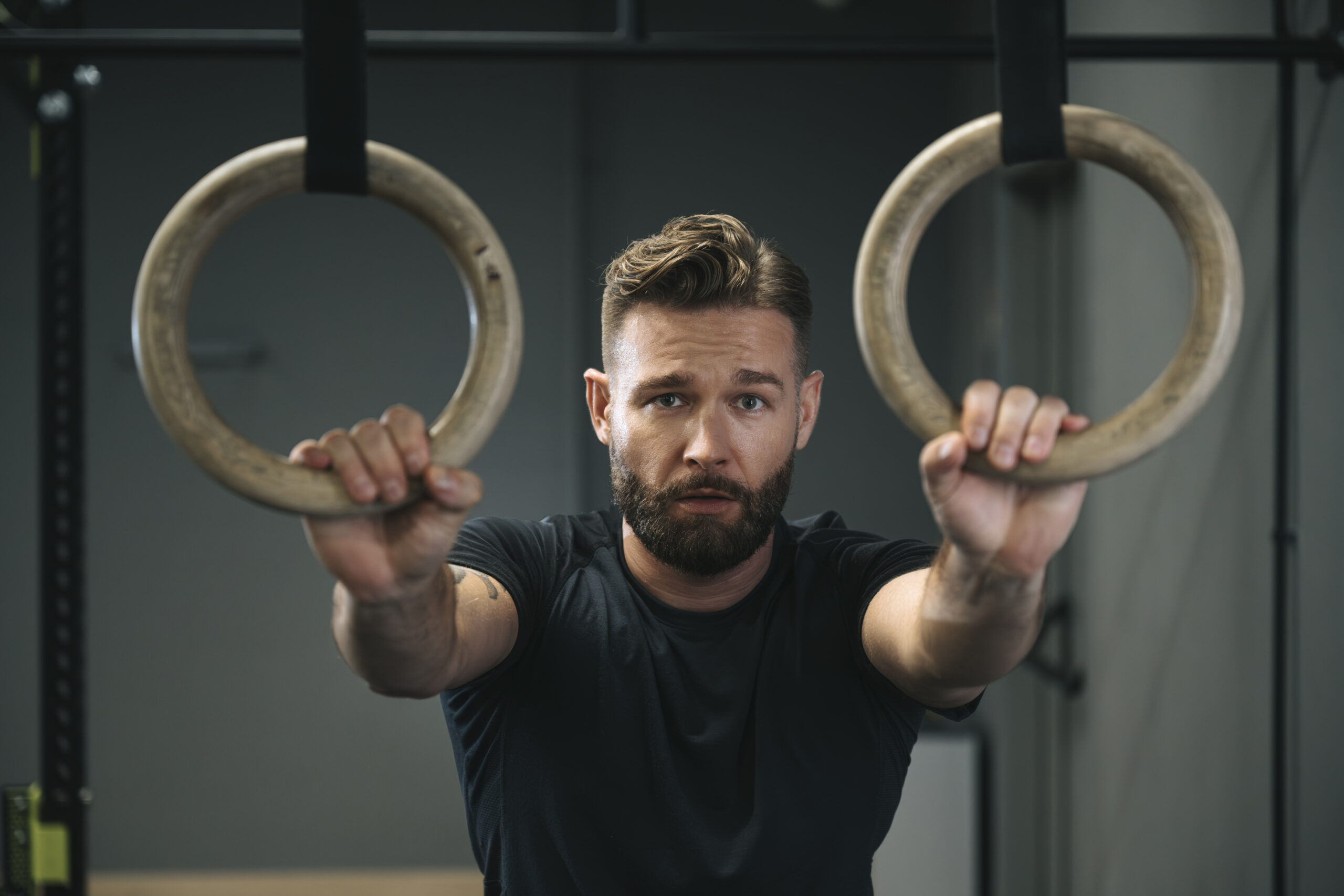 Mężczyzna na siłowni, trzymający kółka gimnastyczne