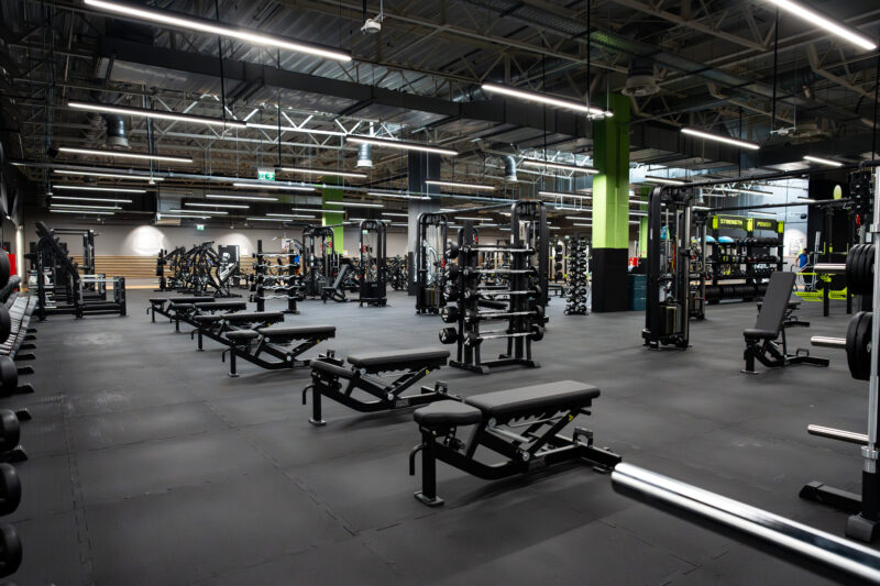 Тренажерні лавки та гантелі у просторому тренажерному залі Well Fitness Piaseczno