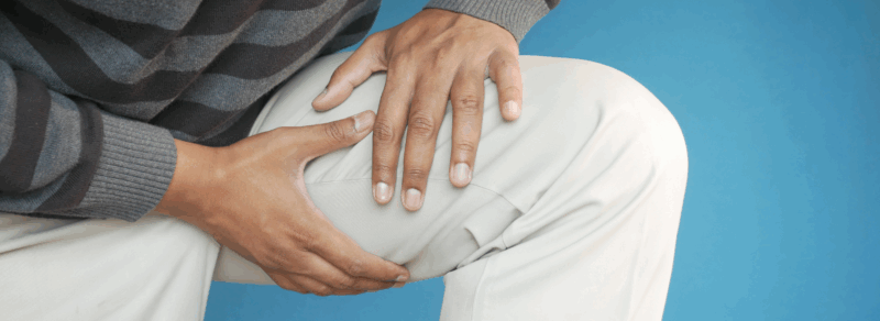 mężczyzna trzymający się za przywodziciela uda