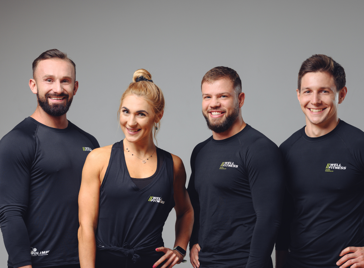 Zespół trenerów Well Fitness – uśmiechnięci, profesjonalni instruktorzy w sportowych strojach