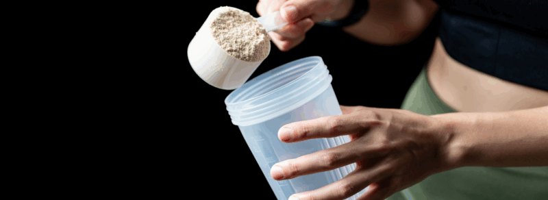 Miarka proszku białkowego wsypywana do shakera – przygotowanie shake proteinowego