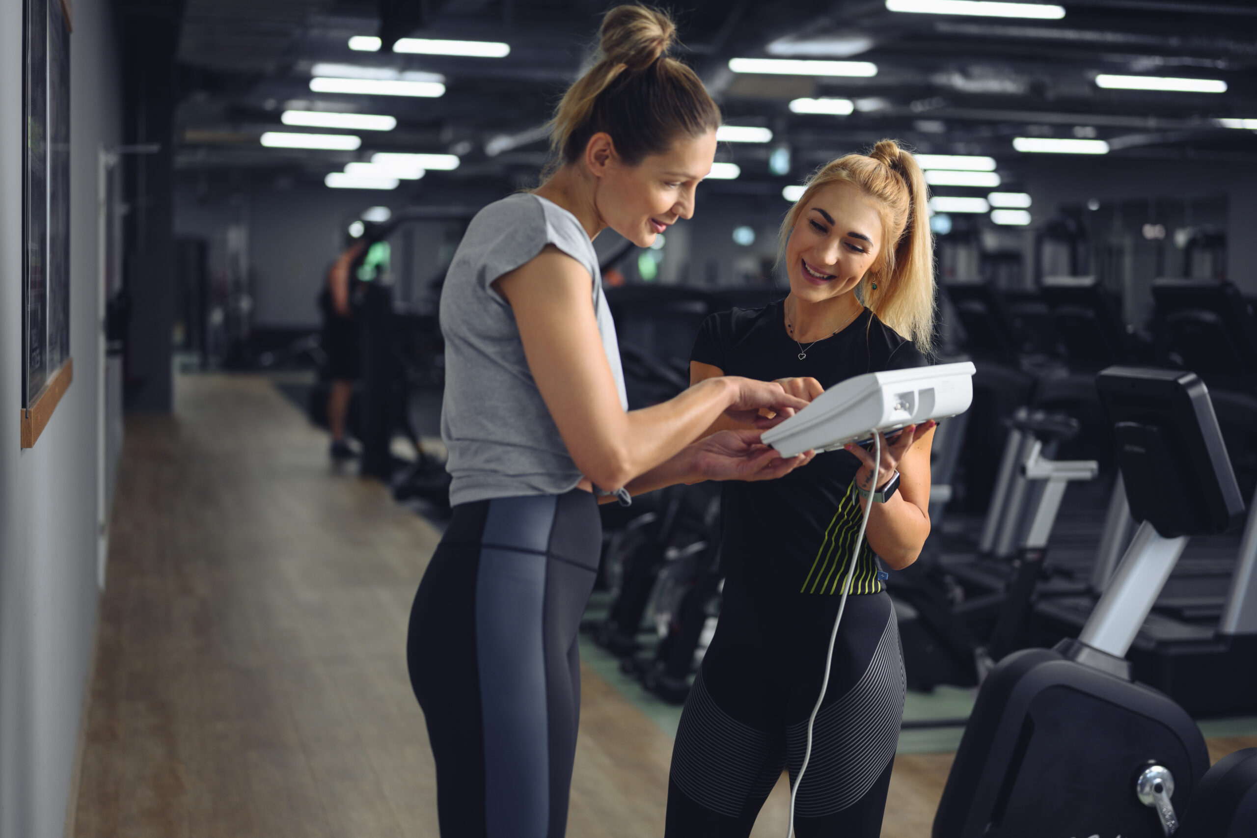 Analiza składu ciała na maszynie InBody – trenerka omawia wyniki z uczestniczką w klubie Well Fitness.