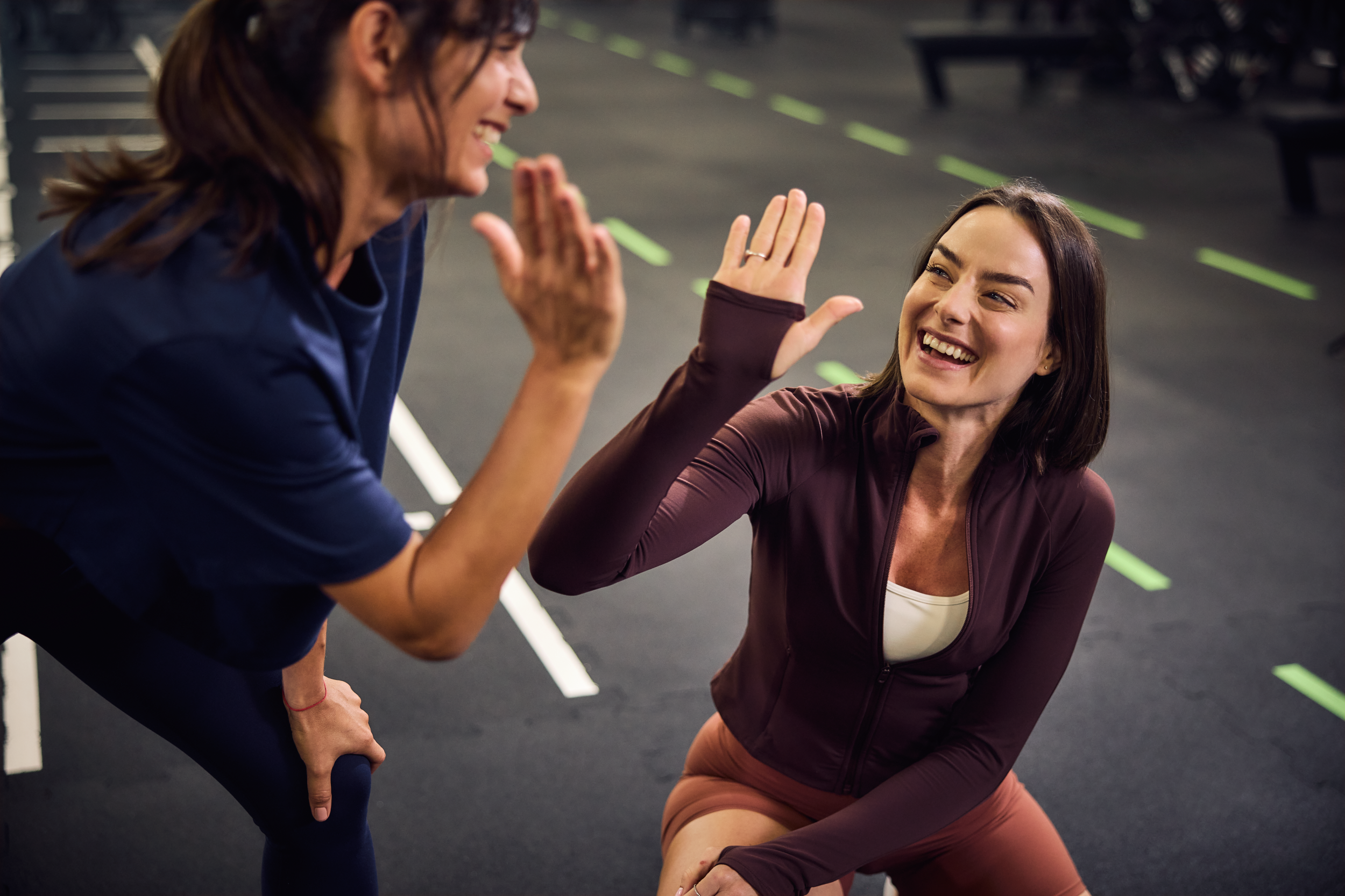 Uśmiechnięte kobiety na siłowni przybijające piątki
